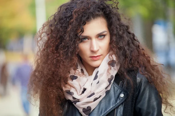 Bella giovane donna con i capelli ricci a piedi in città, foto di primavera — Foto Stock