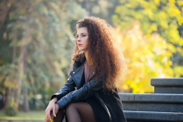 Beautiful young woman with curly hair walking in the city, spring photos — Stok fotoğraf