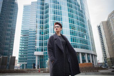 Kısa saçlı ve gözlüklü şehirde yürüyüş ile güzel genç kadın