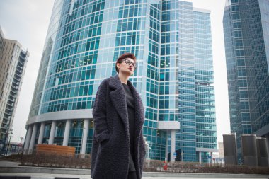 Kısa saçlı ve gözlüklü şehirde yürüyüş ile güzel genç kadın