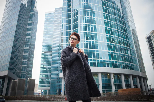 Hermosa joven con pelo corto y gafas caminando por la ciudad — Foto de Stock