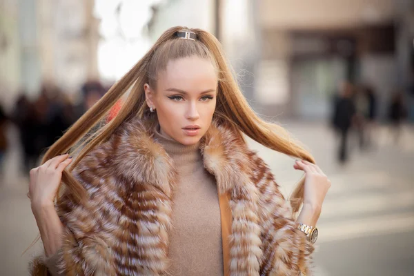 Beautiful young woman with long hair walking in the city — Stock Photo, Image