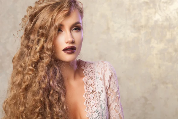 Sexy blonde woman with fashion make-up and curly hair. Skin and hair care concept