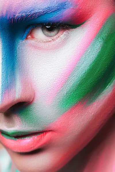 Beautiful fashion woman with bright color face art and body art. Paint on face. Creative portrait