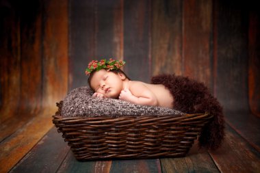 Yeni doğan uyuyan bebek kız güzel bir ahşap zemin üzerinde bir hasır sepet 