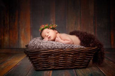 Yeni doğan uyuyan bebek kız güzel bir ahşap zemin üzerinde bir hasır sepet 