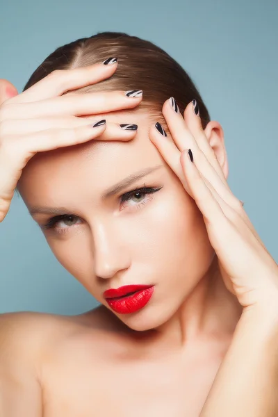 Hermosa mujer natural con maquillaje de moda y cabello rubio, retrato de una joven aislada en azul Imagen De Stock