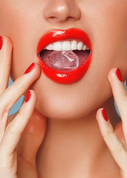 Primer plano de los labios de la mujer con cubo de hielo Fotos De Stock