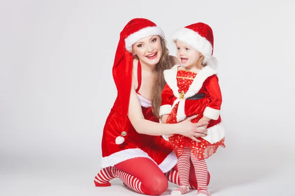 Щасливі матері з маленькою дочкою iin одяг Санта Клауса — стокове фото