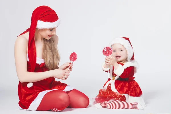 Щасливі матері з маленькою дочкою iin одяг Санта Клауса — стокове фото