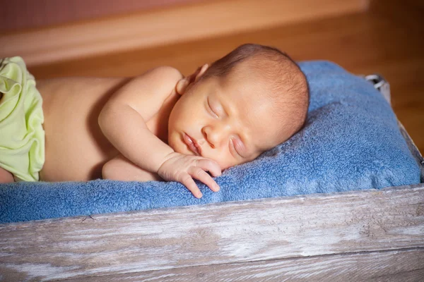 Mooie slapende pasgeboren baby het dragen van een gestreepte hoed — Stockfoto