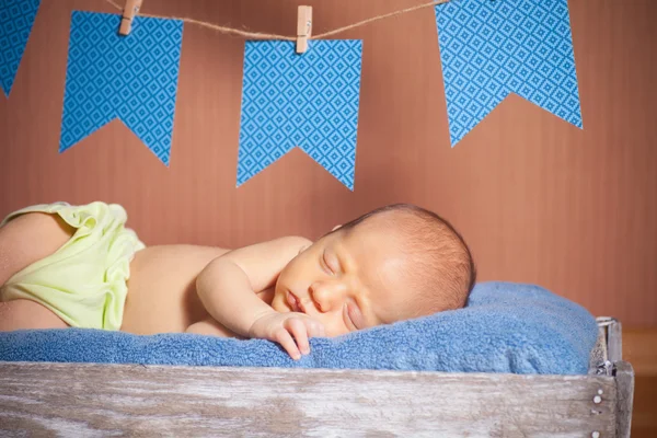 Mooie slapende pasgeboren baby het dragen van een gestreepte hoed — Stockfoto