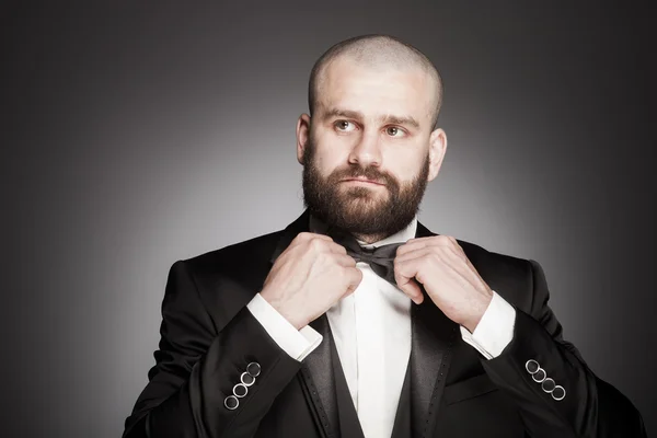 Uomo calvo elegante e brutale con la barba in elegante abito nero — Foto Stock