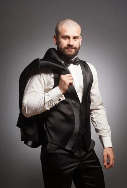 Stylish and brutal bald man with a beard in elegant black suit — Stock Photo, Image