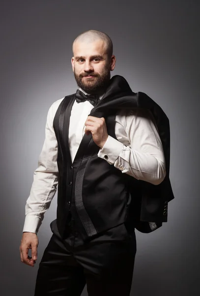 Stylish and brutal bald man with a beard in elegant black suit — Stock Photo, Image