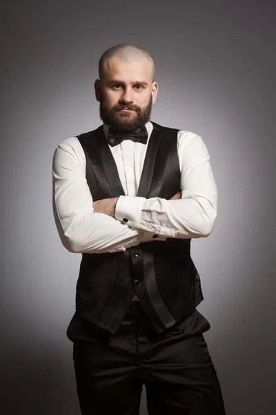 Stylish and brutal bald man with a beard in elegant black suit — Stock Photo, Image