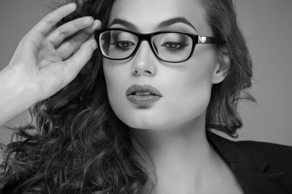 Close-up portrait of beautiful young woman in glasses