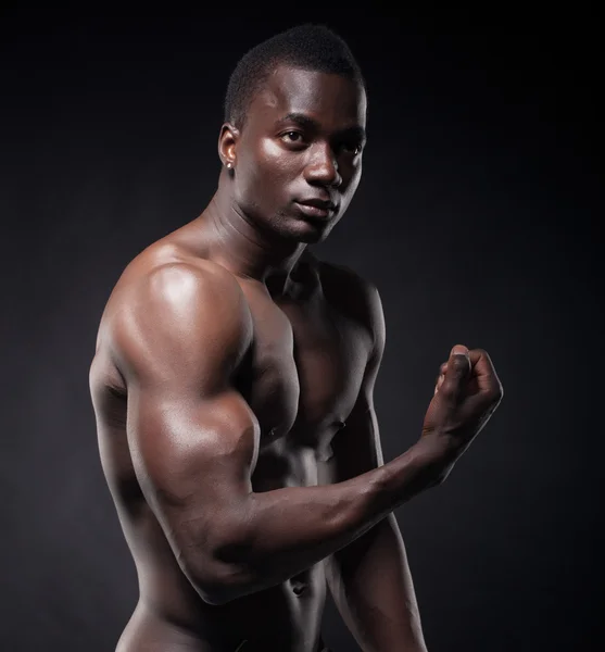 Homem negro bonito e musculoso em fundo escuro — Fotografia de Stock