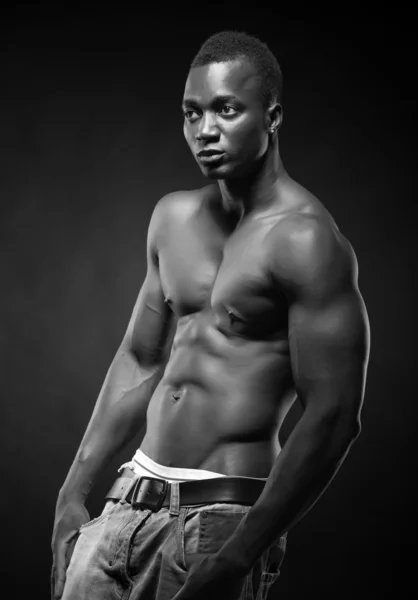 Beautiful and muscular black man in dark background — Stock Photo, Image