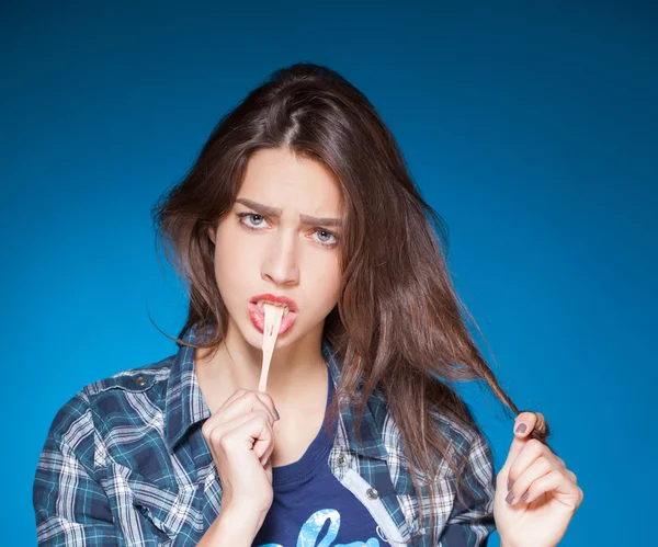 Young beautiful girl posing grimacing with chewing gum — Stock Photo, Image