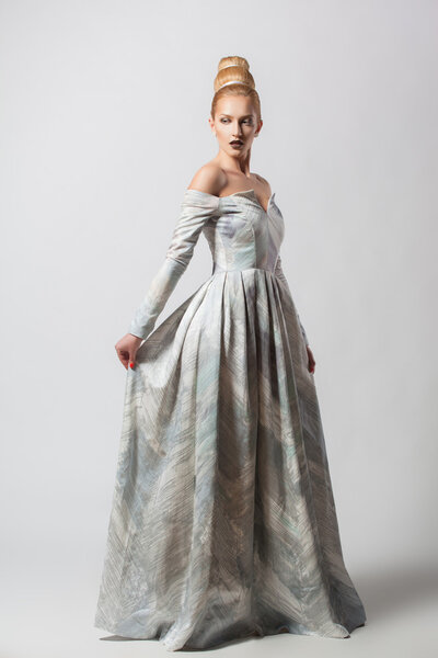Старомодная сексуальная женщина в длинном платье с красивой креативной прической
