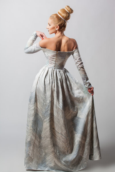 Старомодная сексуальная женщина в длинном платье с красивой креативной прической

