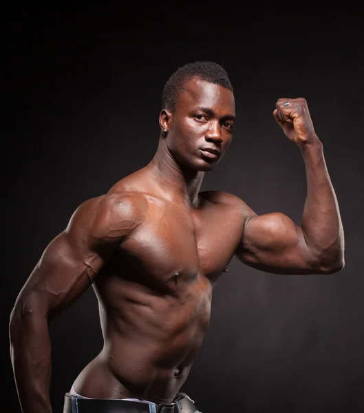 Мбаппе и мускулистый черный человек на темном фоне — стоковое фото