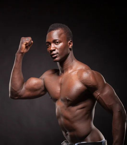 Beautiful and muscular black man in dark background — Stock Photo, Image