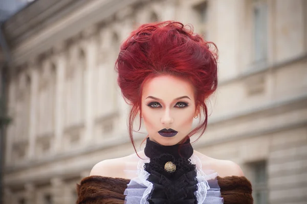 Sexy woman with gothic makeup and red hair and castle — Stock Photo, Image