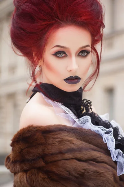 Mujer sexy con maquillaje gótico y pelo rojo y castillo — Foto de Stock