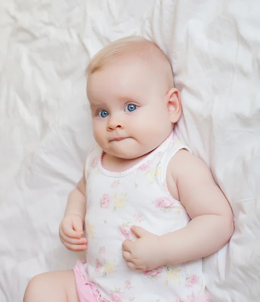 Beautiful baby girl lying on white bed — Stock Photo, Image