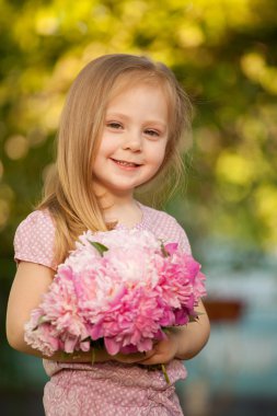 güzel bebek kız açık havada pembe çiçekli. Küçük kız 2-3 yıl eski