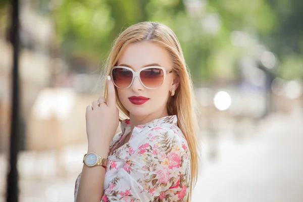 Mujer joven rubia hermosa y de moda con gafas de sol caminando por la ciudad. Foto de verano —  Fotos de Stock