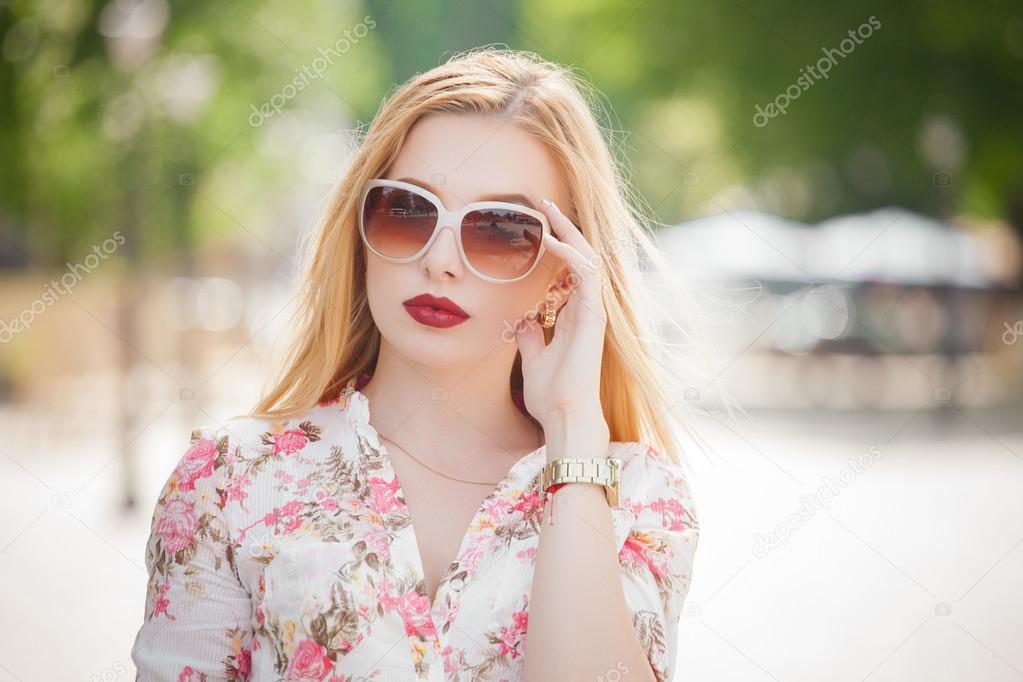 Beautiful  and fashion blonde young woman with sunglasses walking in the city. Summer photo