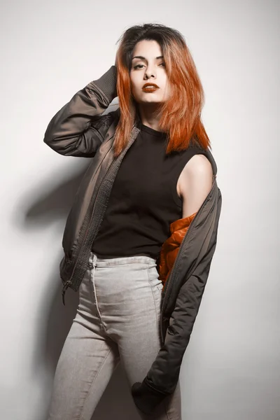 Jeune femme en veste et jeans bleus avec des cheveux roses studio tourné — Photo