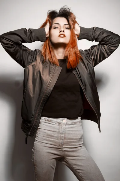 Jeune femme en veste et jeans bleus avec des cheveux roses studio tourné — Photo