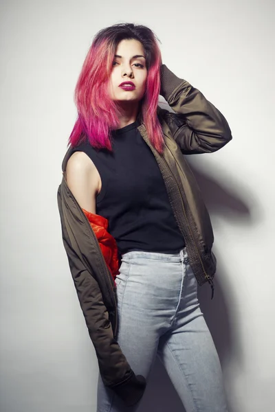 Jeune femme en veste et jeans bleus avec des cheveux roses studio tourné — Photo