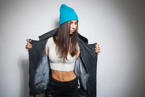 Hipster menina em jeans rasgado, colete jeans e chapéu azul — Fotografia de Stock