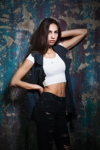 Sexy hipster girl in torn jeans and denim vest — Stock Photo, Image