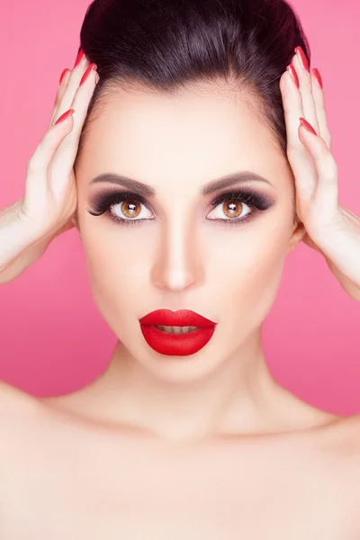 La mujer de moda con los labios sensuales rojos y la cara hermosa - aislado en rosa. Concepto de cuidado de la piel . —  Fotos de Stock