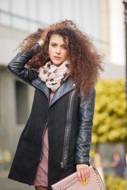 Şehirde yürüyüş kıvırcık saçlı güzel genç kadın. Sonbahar fotoğraf