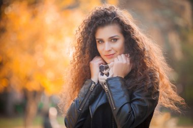 Şehirde yürüyüş kıvırcık saçlı güzel genç kadın. Sonbahar fotoğraf