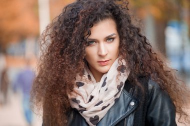 Şehirde yürüyüş kıvırcık saçlı güzel genç kadın. Sonbahar fotoğraf