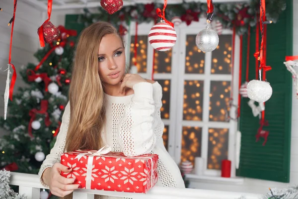 Schoonheid mode vrouw met kerst geschenkdoos, nieuwjaar boom achtergrond — Stockfoto