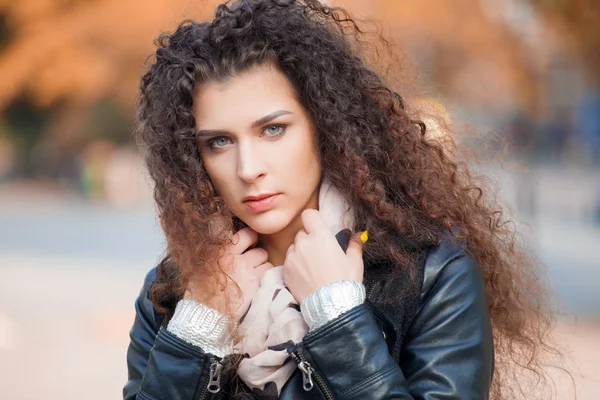 Schöne junge Frau mit lockigem Haar, die durch die Stadt spaziert. Herbstfoto — Stockfoto