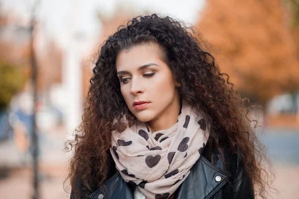 Mooie jonge vrouw met krullend haar lopen in de stad. Herfst foto — Stockfoto