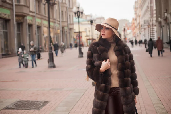 Beautiful and fashion young woman walking on the winter street — Stock Photo, Image