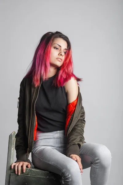 Jovem mulher de jaqueta e jeans azul com rosa estúdio de cabelo tiro — Fotografia de Stock