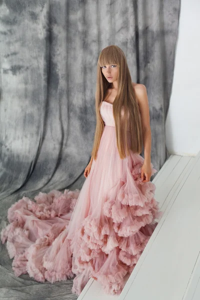Retrato de una mujer de moda en precioso vestido largo rosa — Foto de Stock