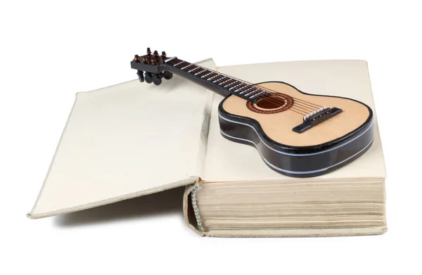 アコースティックギターモデルは古い本にあります 白い背景に孤立したオブジェクト — ストック写真